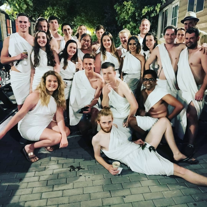 Group of people wearing togas at a party.