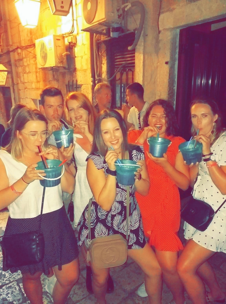 Groupe de personnes buvant dans de grands verres la nuit.