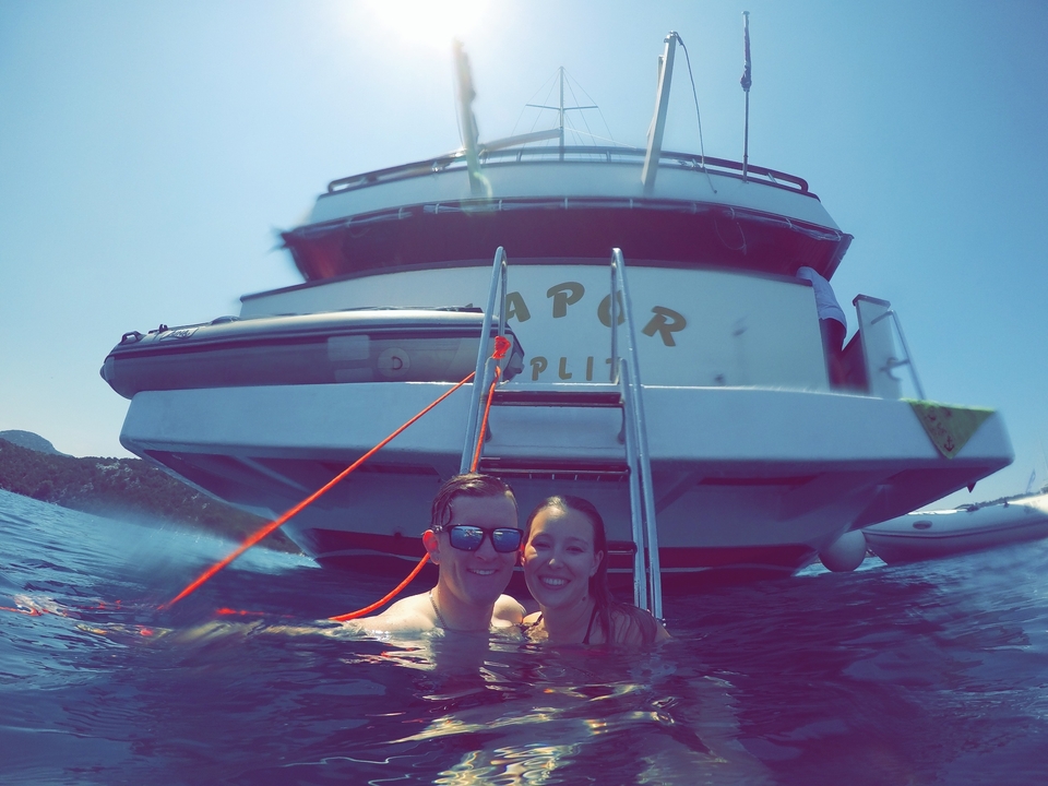 Couple dans l'eau près d'un navire avec 'Split' écrit dessus.