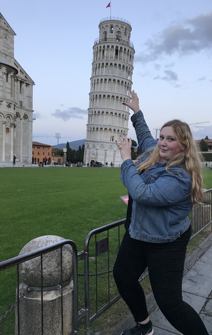 Person posing with Leaning Tower of Pisa.