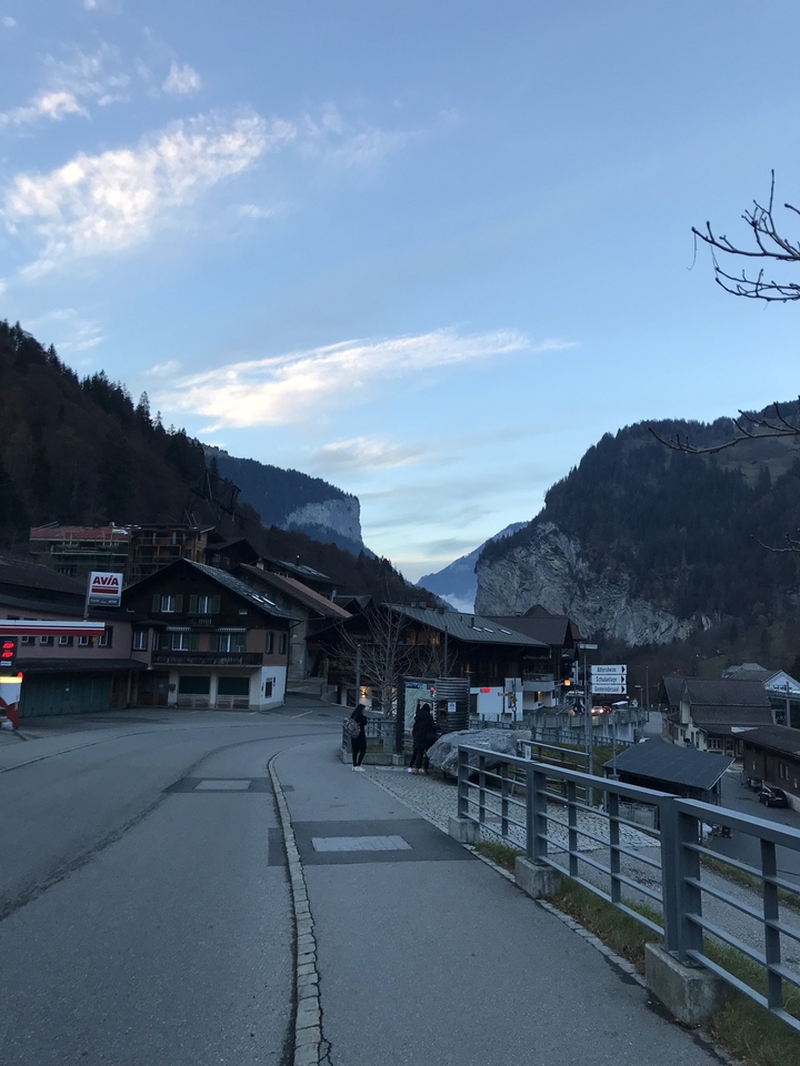 Scenic view of a mountain village with houses and road signs.