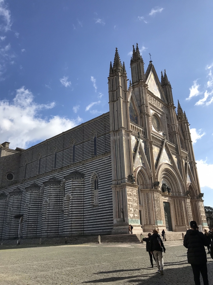 Cathedral with striped facade against blue sky.