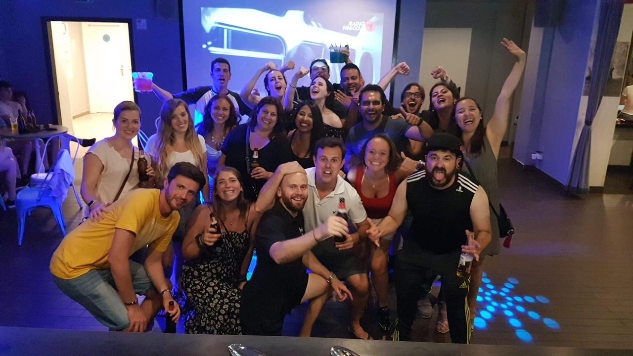 A group of people enjoying drinks and dancing indoors.