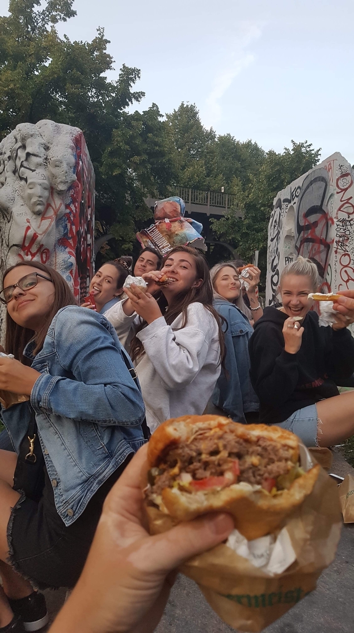 A group of people enjoying food together, laughing and smiling.