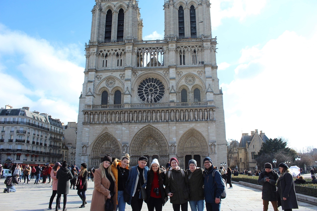 Group posing in front of Notre-Dame Cathedral in Paris.