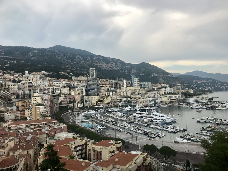 Panoramic view of Monaco with marinas and hills.