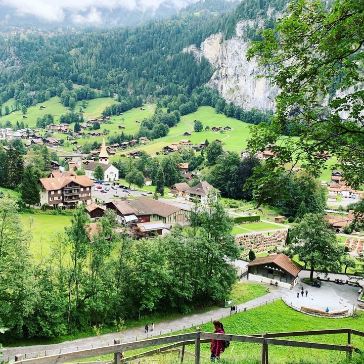 Scenic village view with lush greenery and a church.
