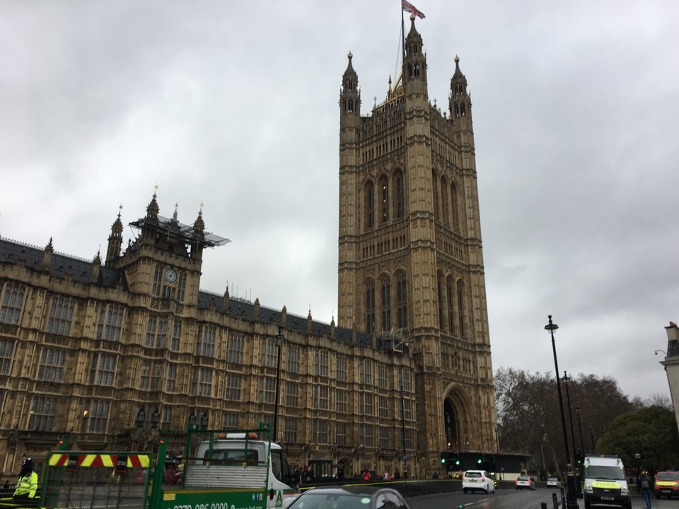 Tall historic tower with gothic architecture against a cloudy sky.
