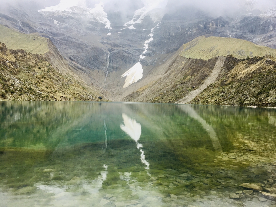 Lac turquoise serein entouré de montagnes escarpées.
