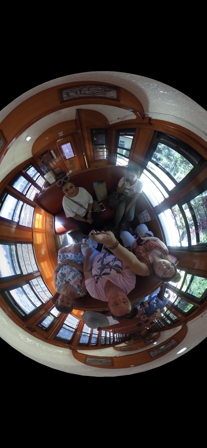 Groupe de personnes à l'intérieur d'un train ou d'un tramway souriant pour une photo.