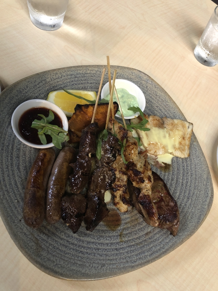 Délicieux plat de viande grillée et saucisses avec sauces et garniture.