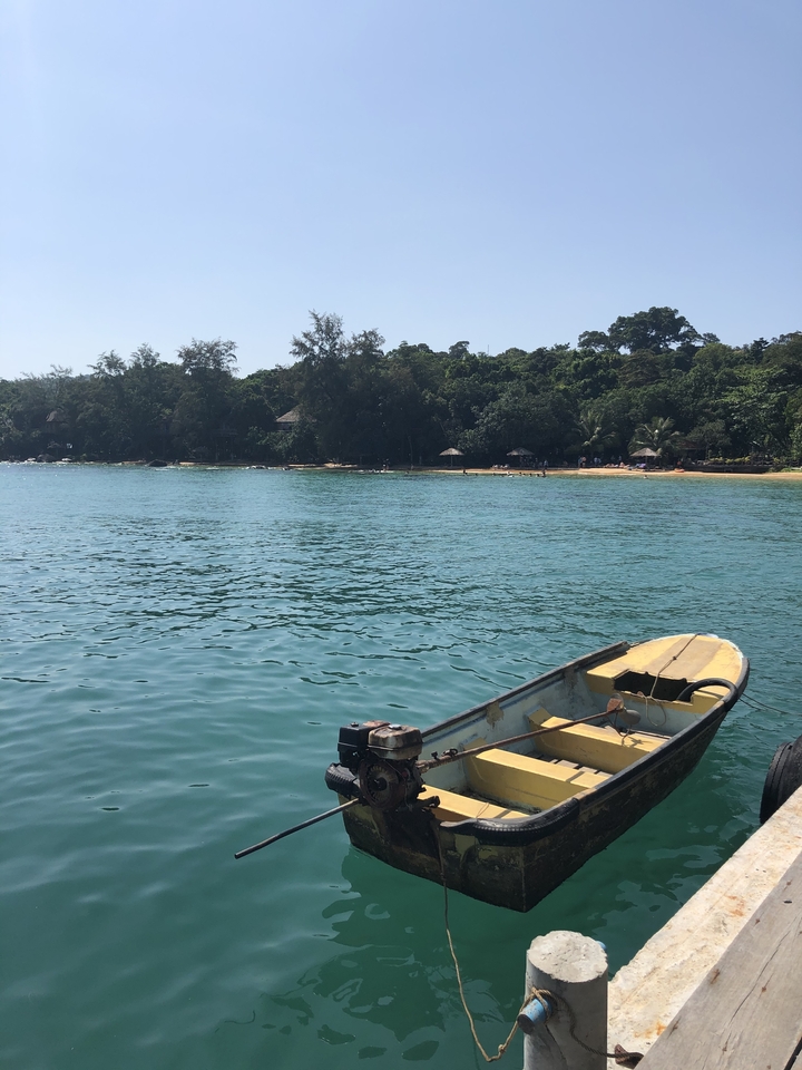 Bay with calm water and traditional boats docked near the shore.