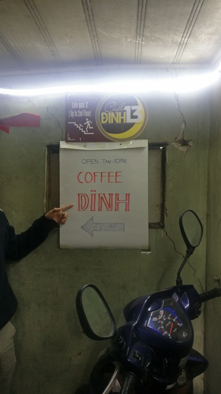 Une main qui pointe vers une enseigne de café.