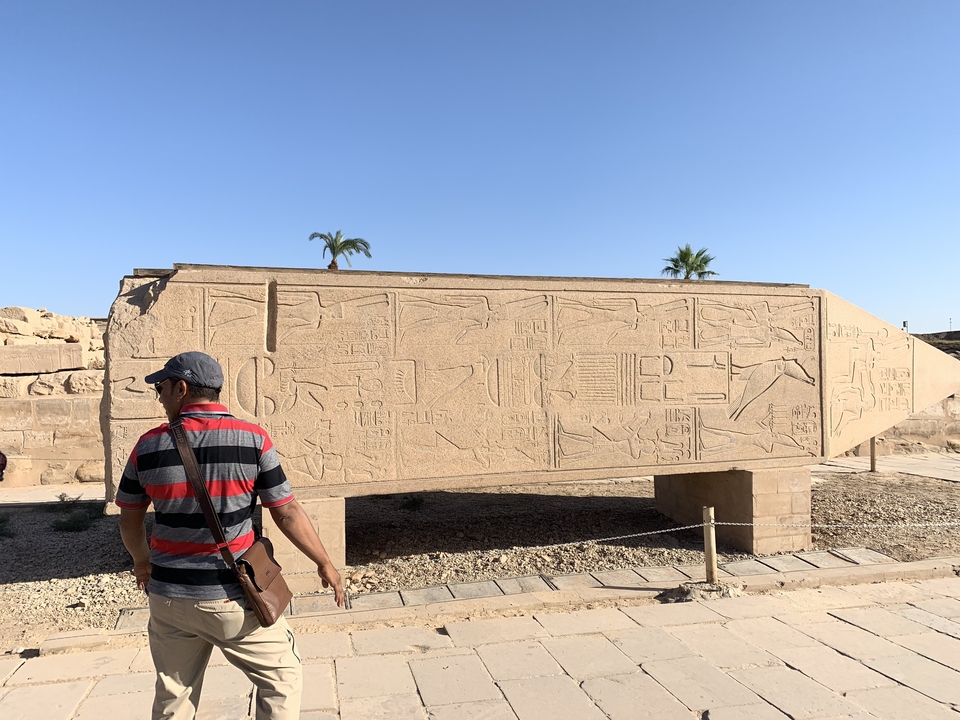 Touriste à côté d'un obélisque ancien avec des hiéroglyphes