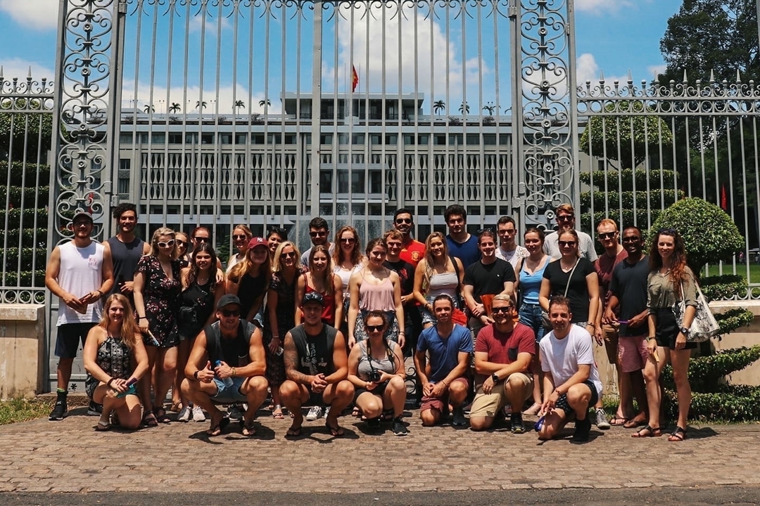 Large group posing in front of the Independence Palace gate.