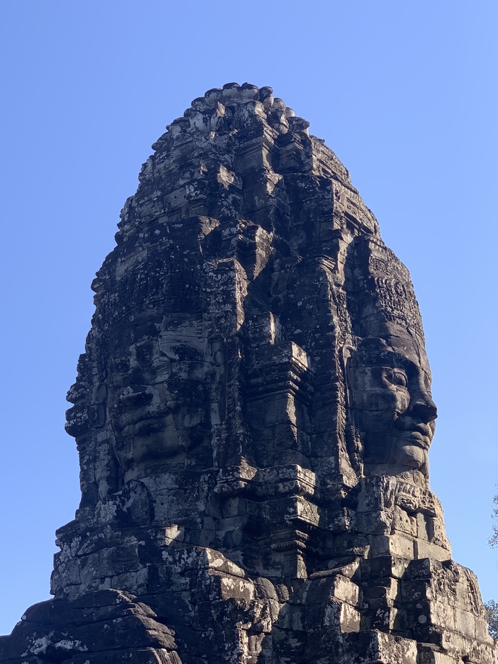 Close-up of a stone sculpture with multiple faces, part of Angkor Wat.