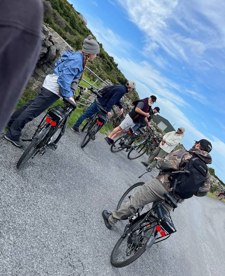 Group of cyclists paused on a road.
