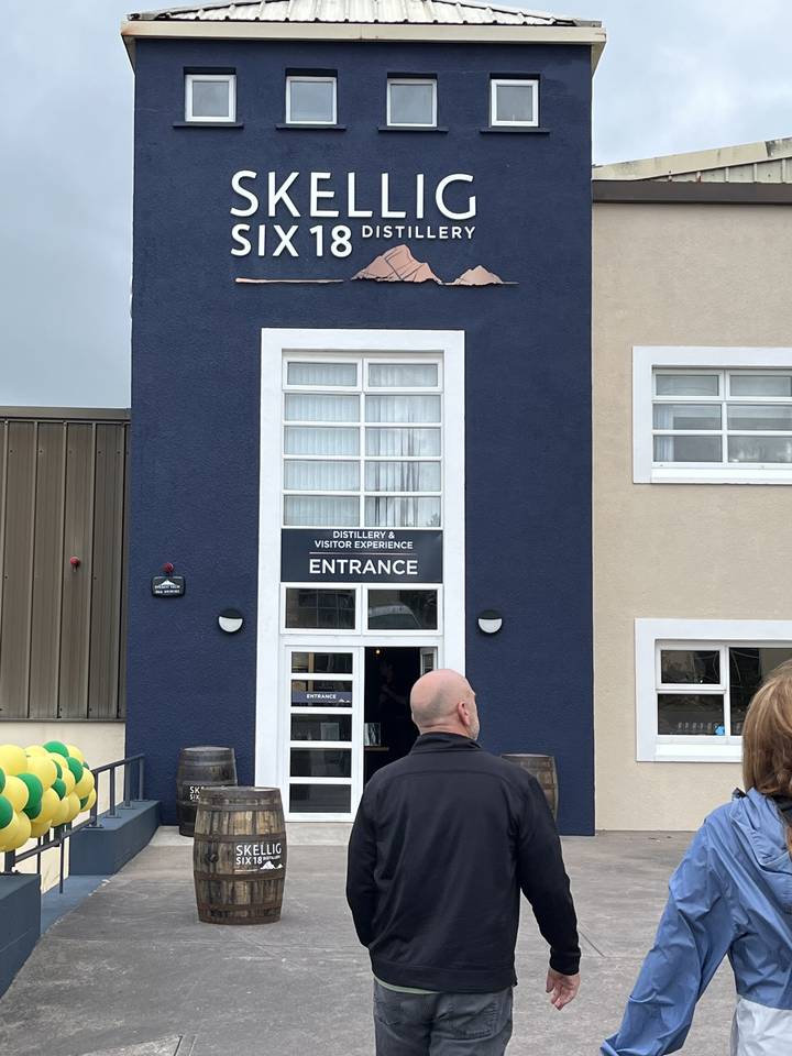 Person standing outside a distillery entrance.