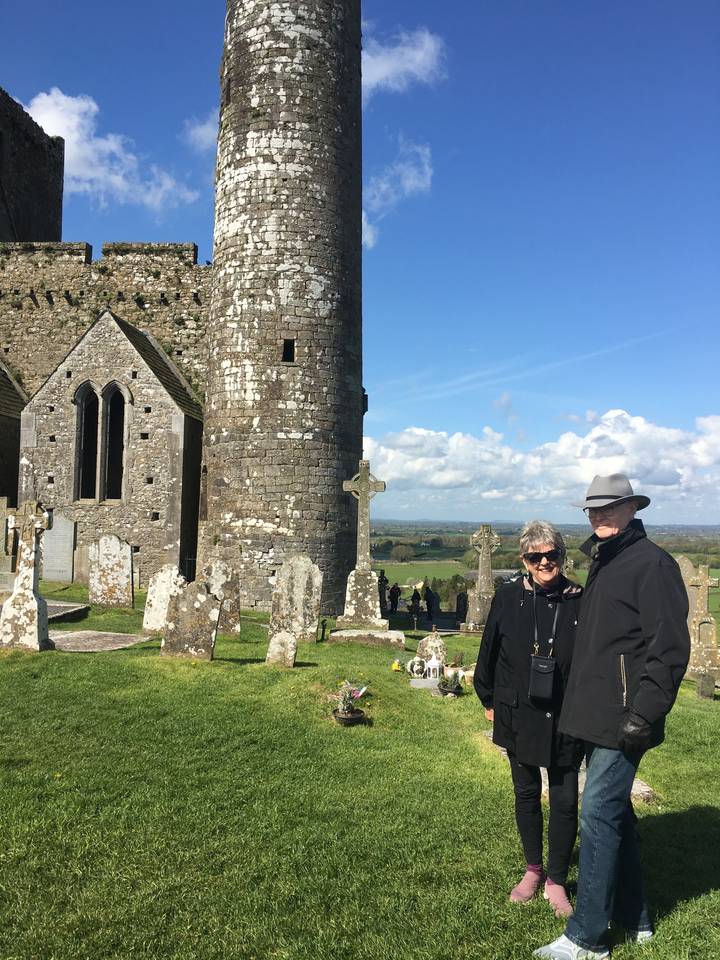 Deux personnes debout près d'une tour de pierre.