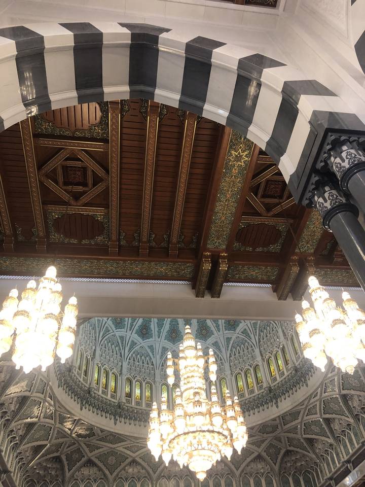 Interior architectural detail with chandeliers and ornate designs.