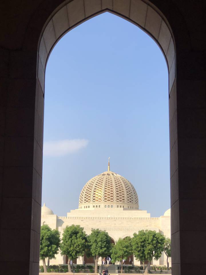 Dome of a grand mosque seen through an archway.