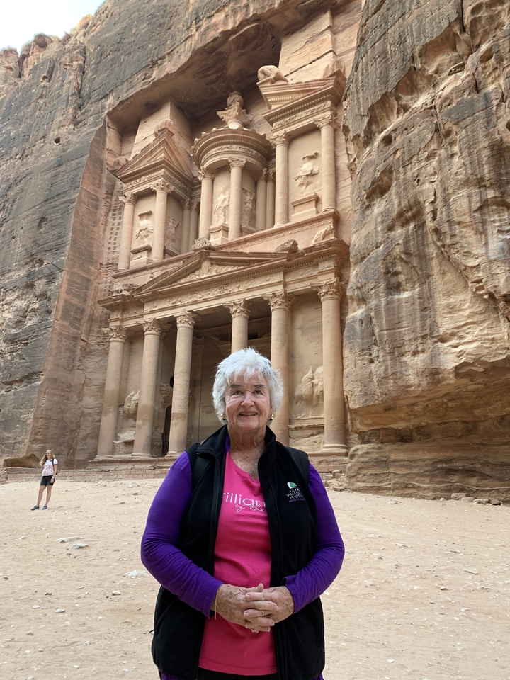 Person posing in front of Petra's Al-Khazneh.