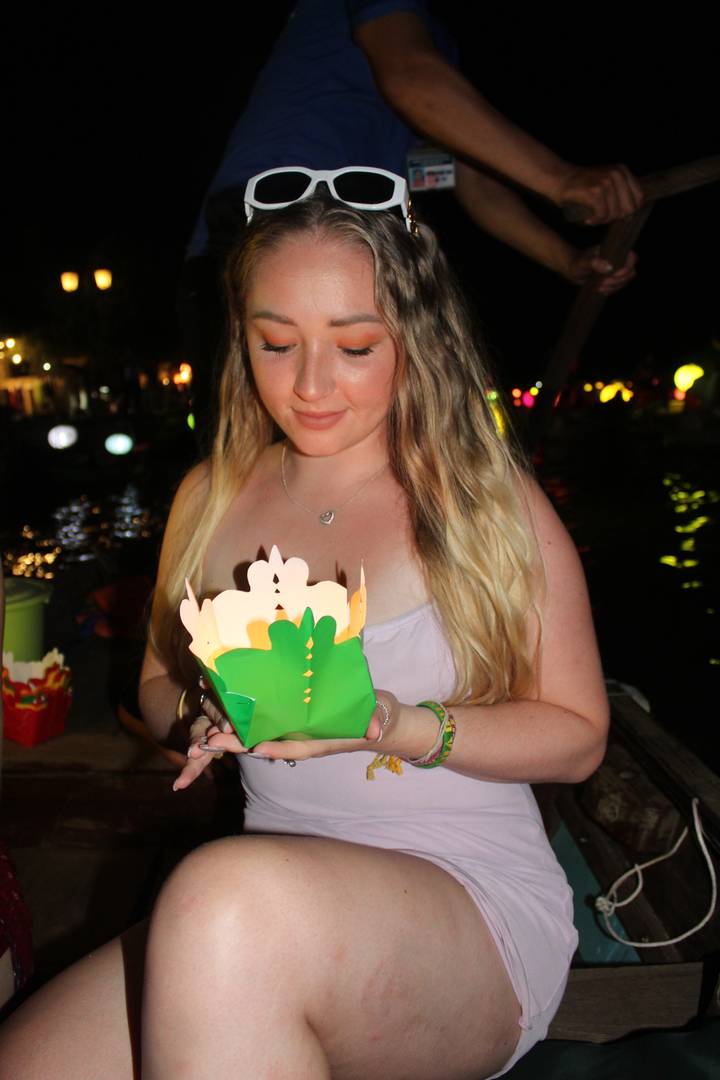 Femme tenant un objet décoratif lors d'un événement nocturne.