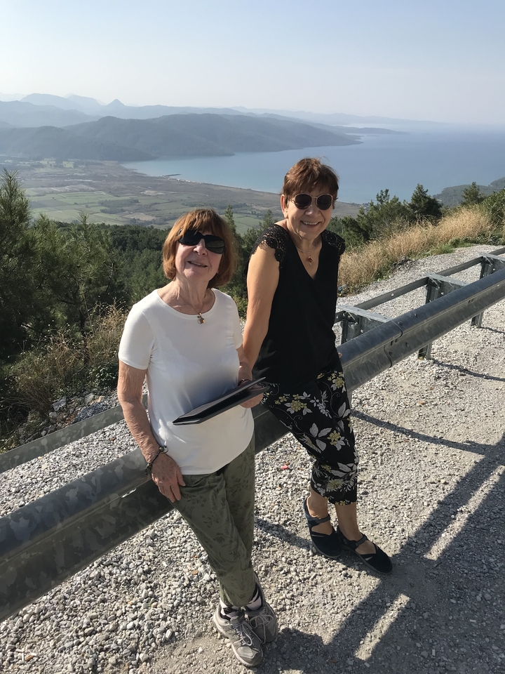 Deux femmes posant sur un sentier de gravier avec vue sur le paysage.