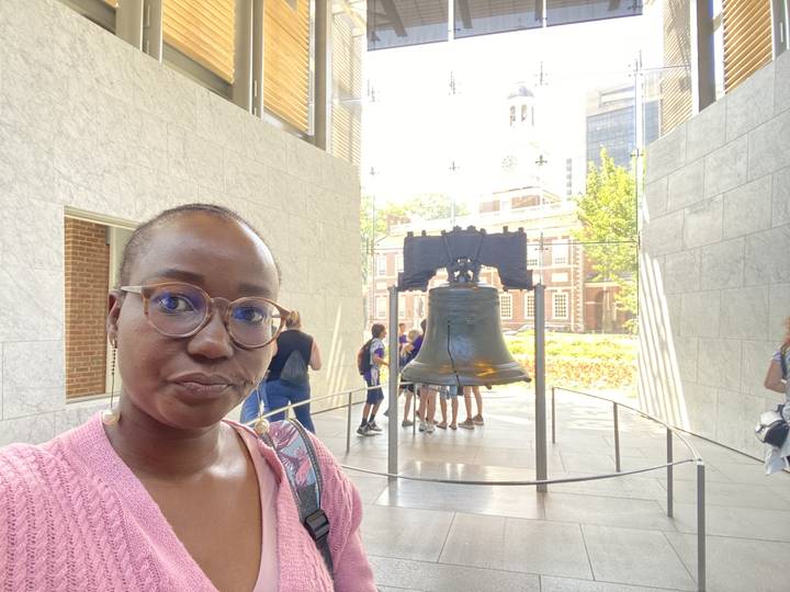 Personne posant avec la Cloche de la Liberté.