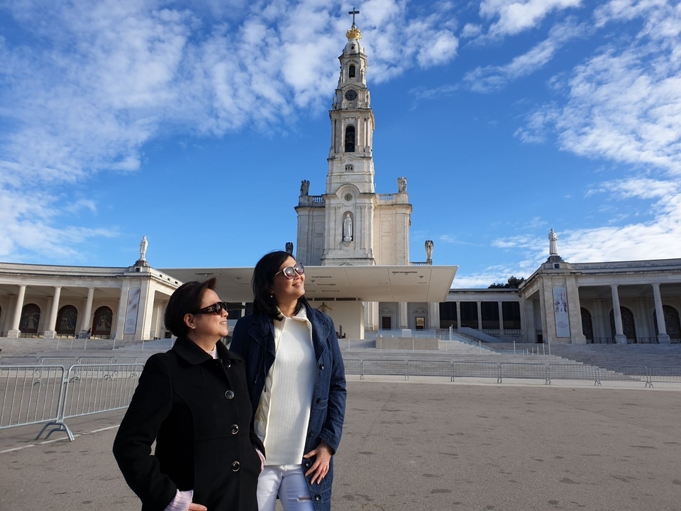 Deux personnes se tenant debout devant une grande architecture religieuse.