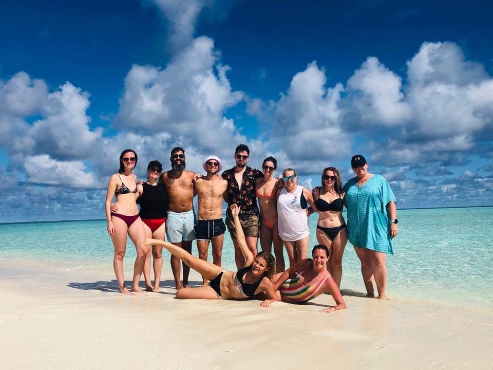 Grupo de amigos posando en una playa tropical.