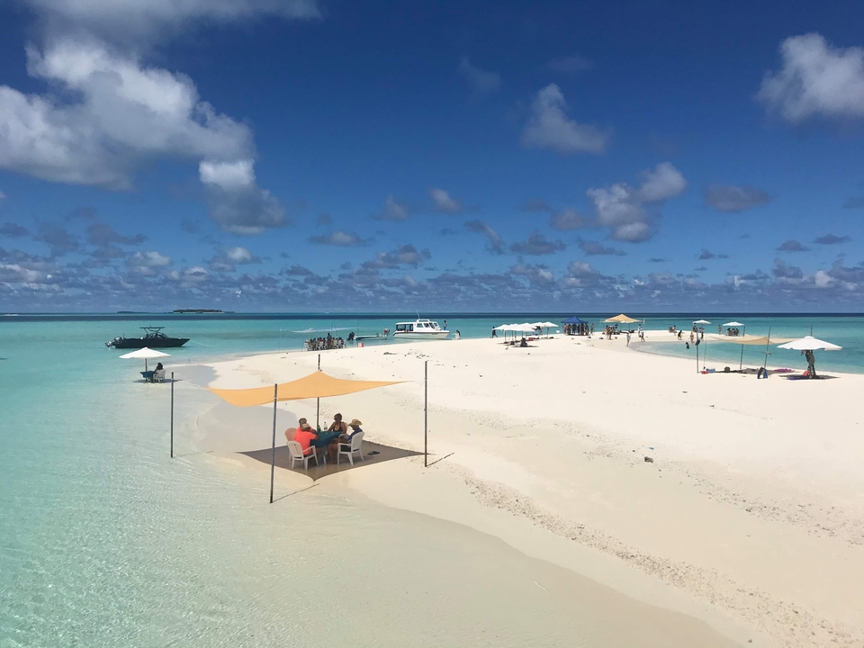 Vista de un banco de arena with carpas y agua turquesa.