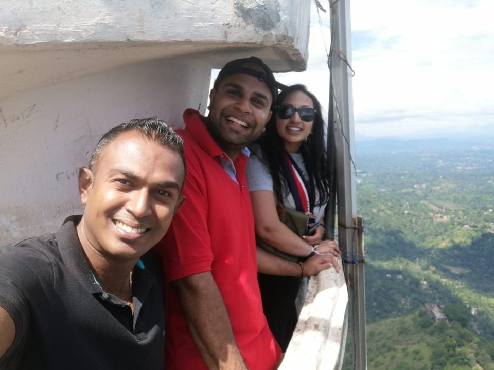 A small group of people taking a selfie from a high viewpoint.