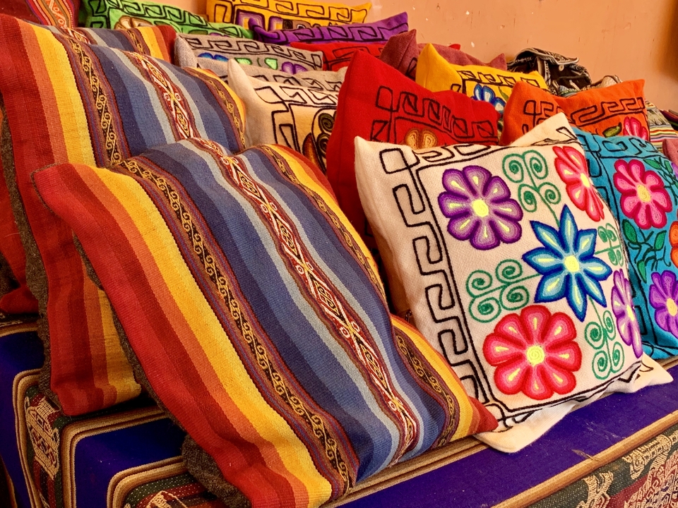 Coussins colorés et brodés empilés ensemble en présentation.