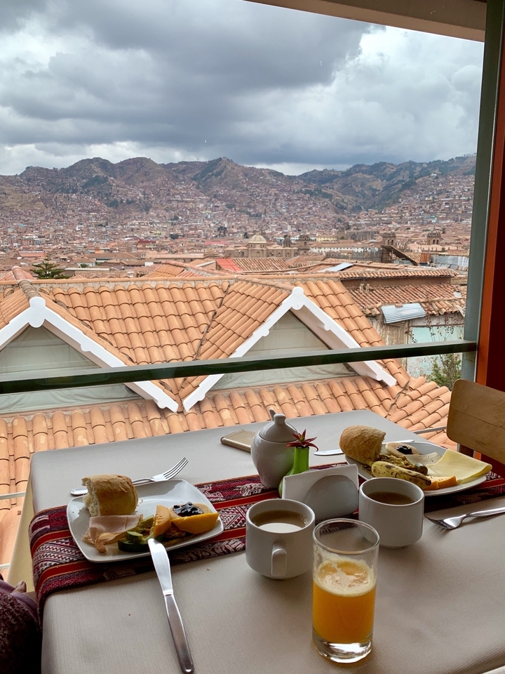Vue sur la ville par-dessus les toits depuis un restaurant avec table et nourriture.