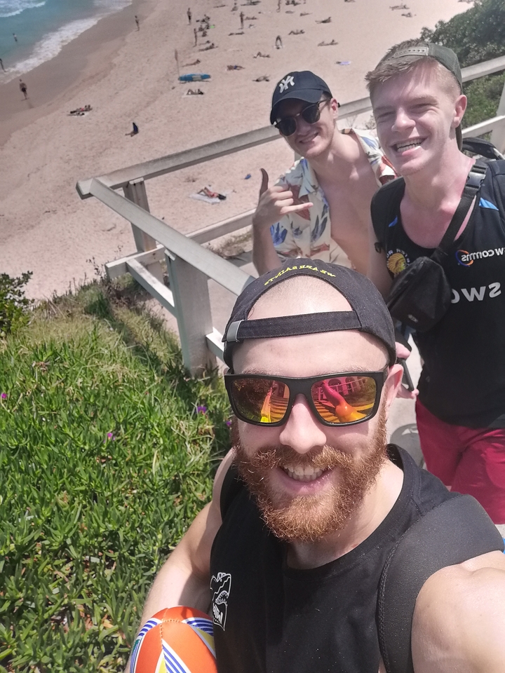 Groupe marchant sur un sentier de plage, prenant des selfies.