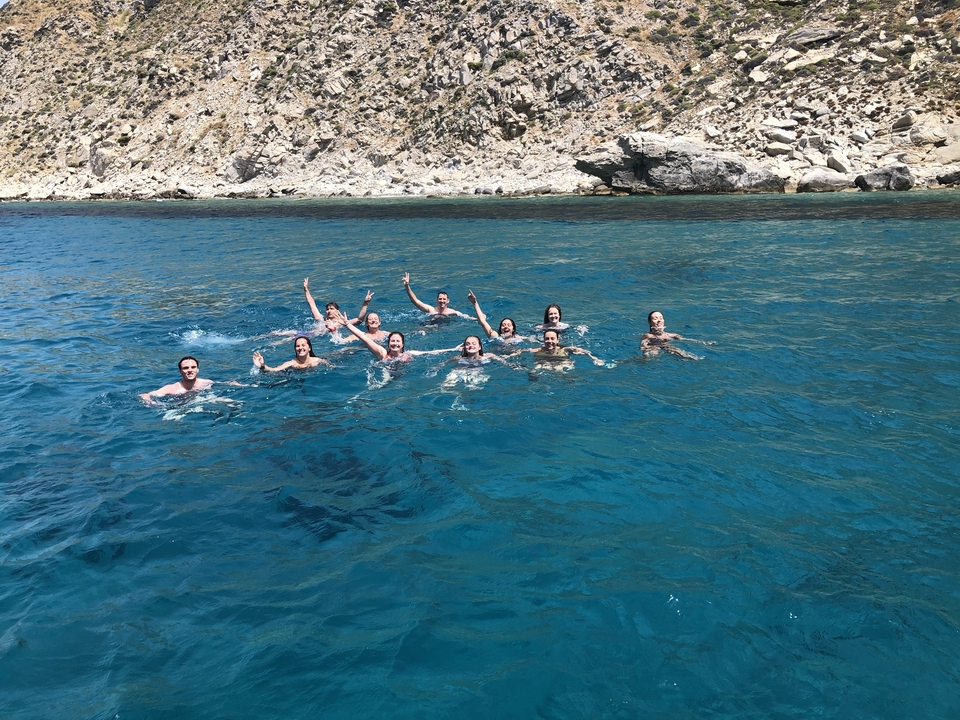 Group of people swimming in clear blue water.