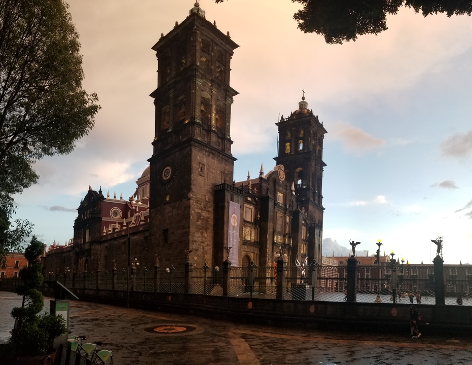 Une cathédrale historique avec une architecture détaillée au premier plan et une cour.