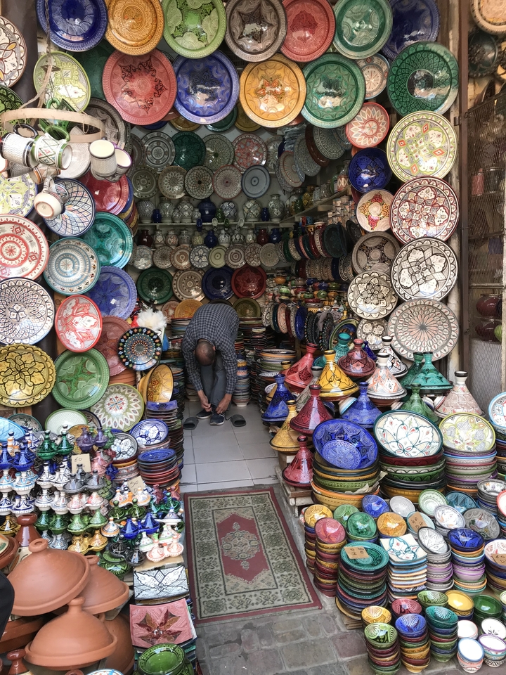 Colorful pottery shop with various items on display.