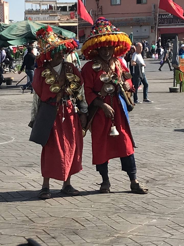 Two traditional water sellers with brass cups.
