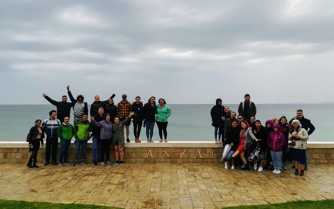 Large group of people posing by the sea