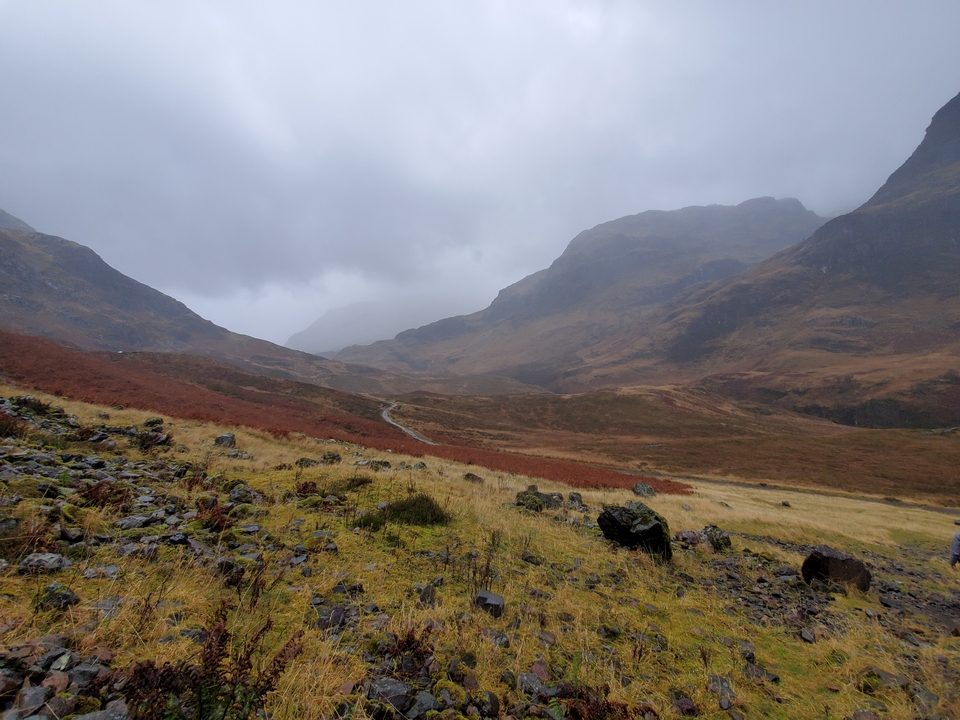 Distant blurry view of foggy mountains with a rocky foreground.