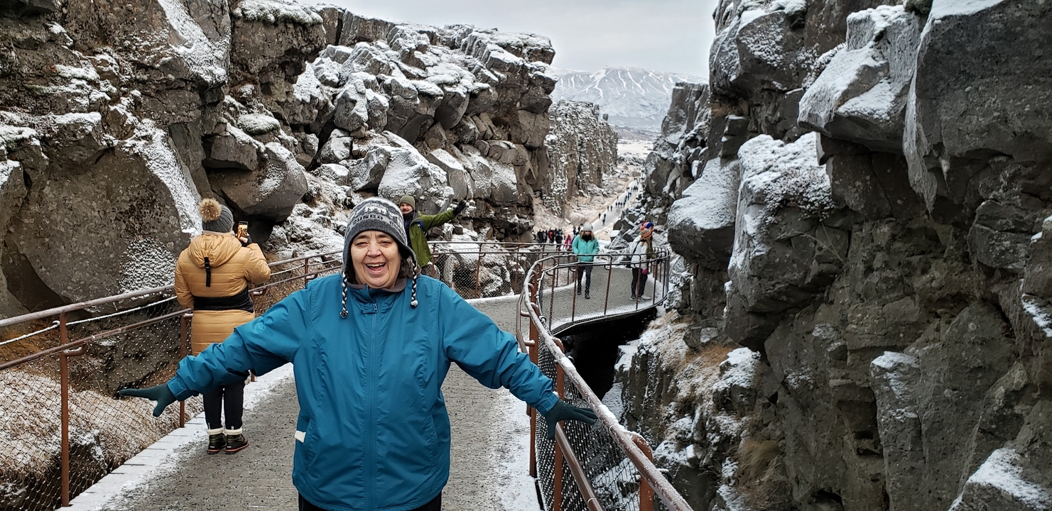 Happy person with a snowy canyon in the background.