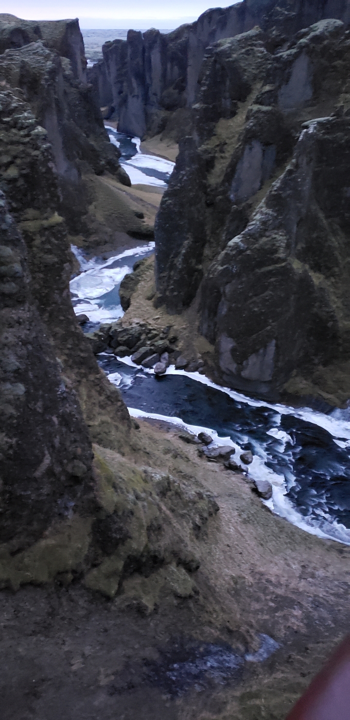 Rock-rimmed river flowing through a rocky landscape.