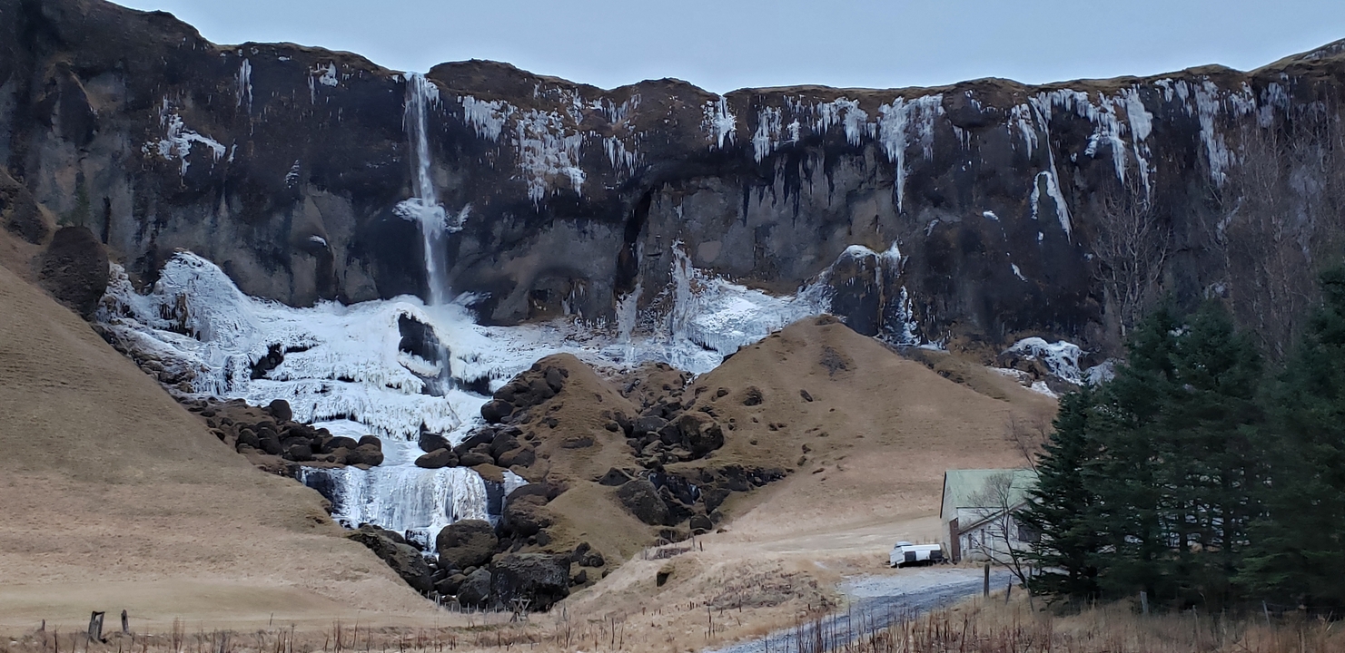 Frozen waterfall on a rocky cliffside.