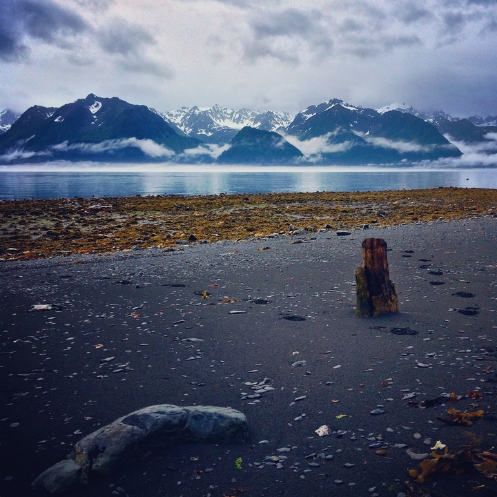 A serene lake with mountains and mist in the background.