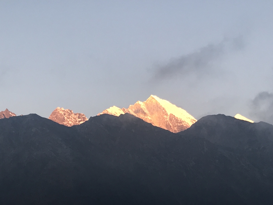 Chaîne de montagnes enneigée au lever ou au coucher du soleil.