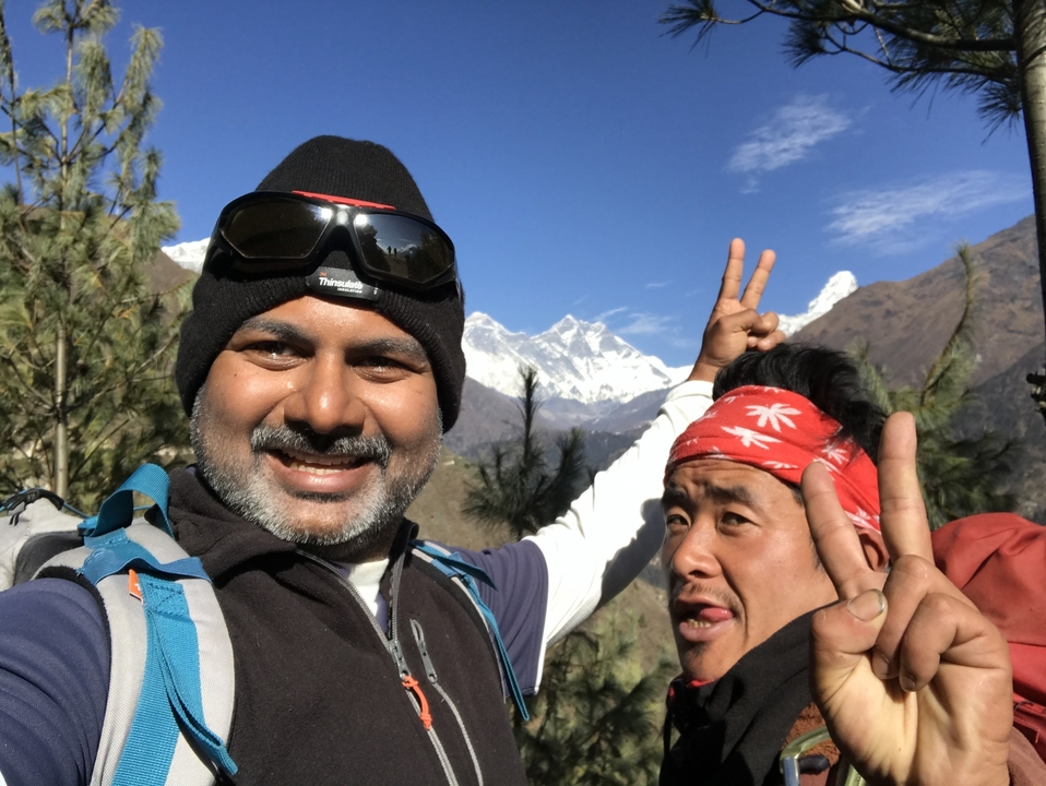 Deux personnes posant avec des montagnes en arrière-plan.