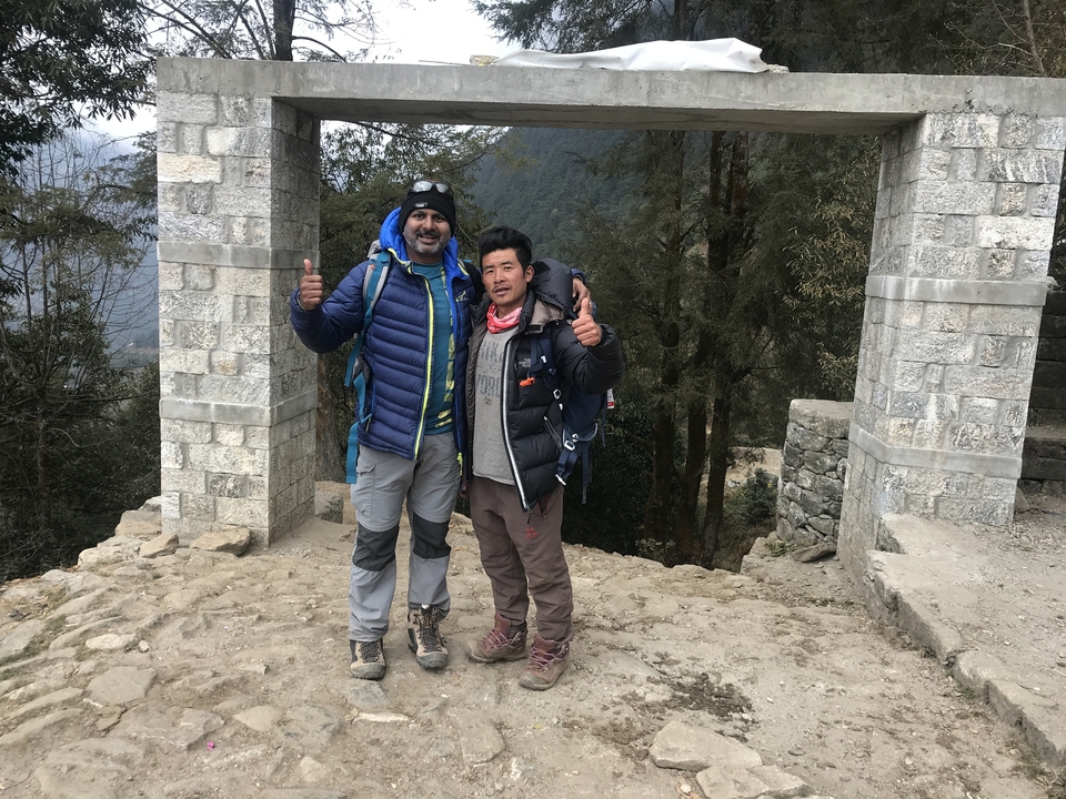 Deux personnes posant sous une structure de pierre voûtée.