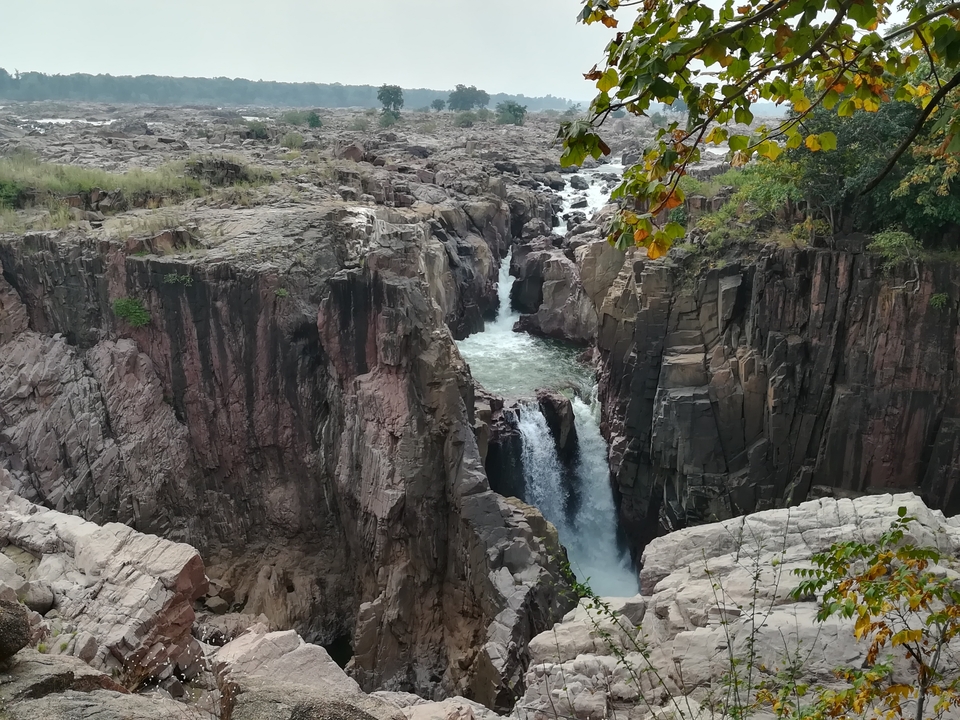 Scenic waterfall cutting through rocky cliffs.